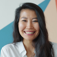 Smiling professional in a white top, circular portrait