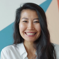 Smiling professional in a white top, circular portrait