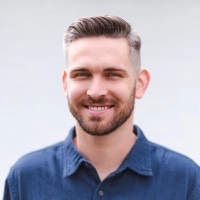 Smiling professional in a blue shirt, circular portrait