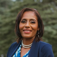 Smiling professional in a blue blazer, circular portrait