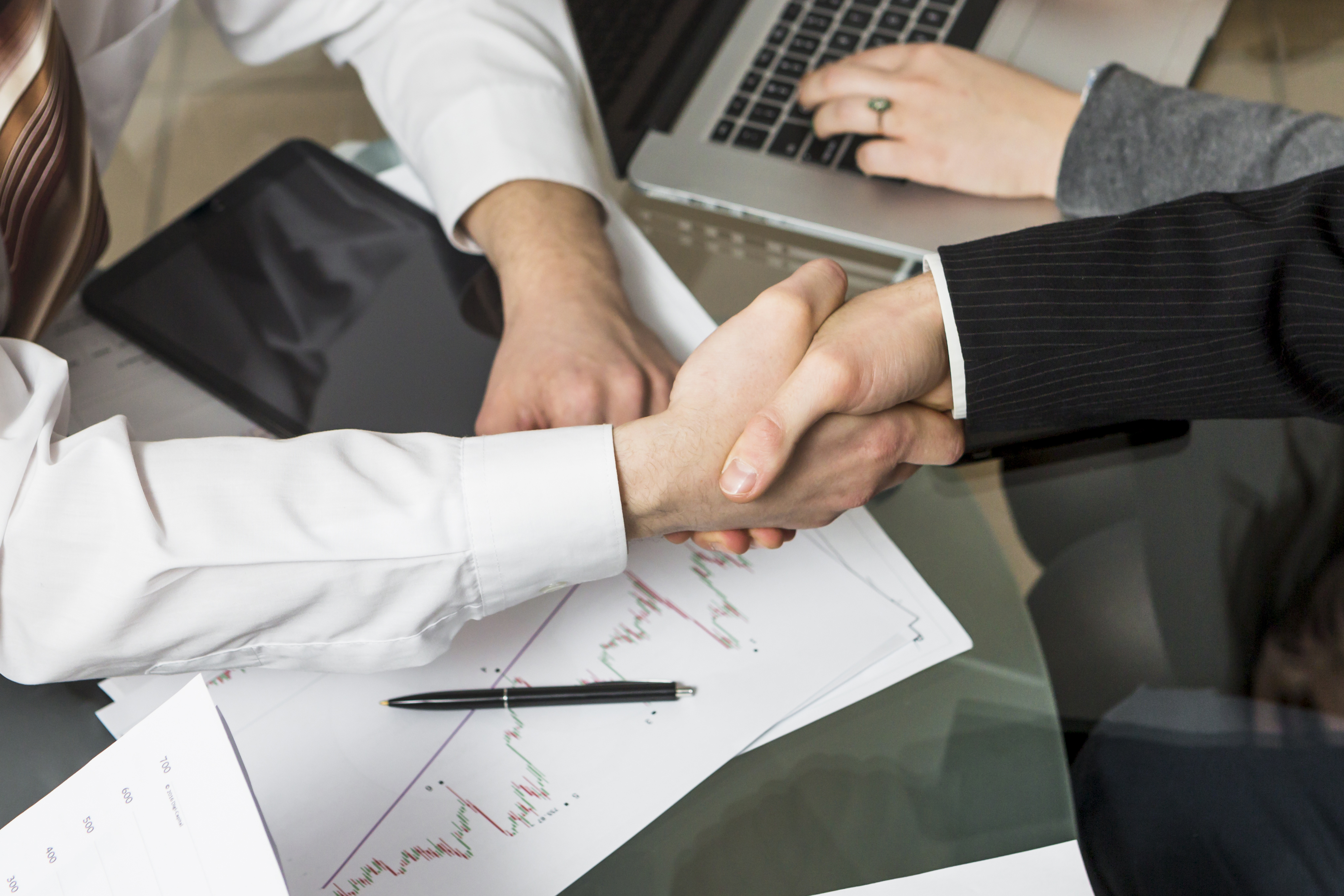 Close-up of two businesspeople shaking hands in a professional setting