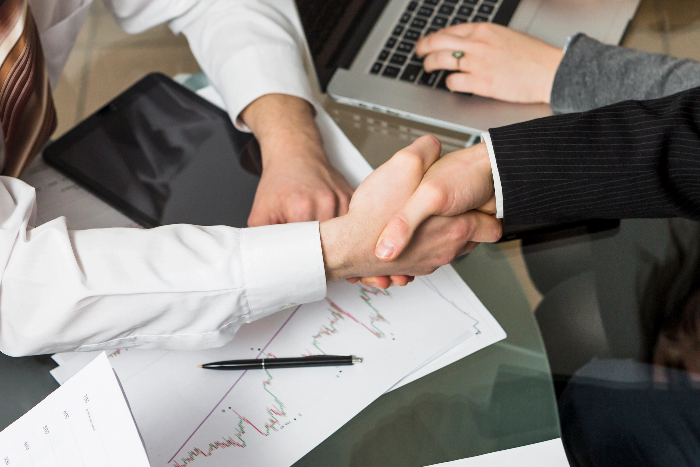 Close-up of two businesspeople shaking hands in a professional setting