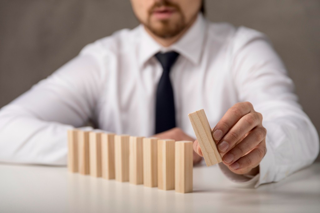 Hand placing a wooden block in a careful row, suggesting structured building blocks and comparison